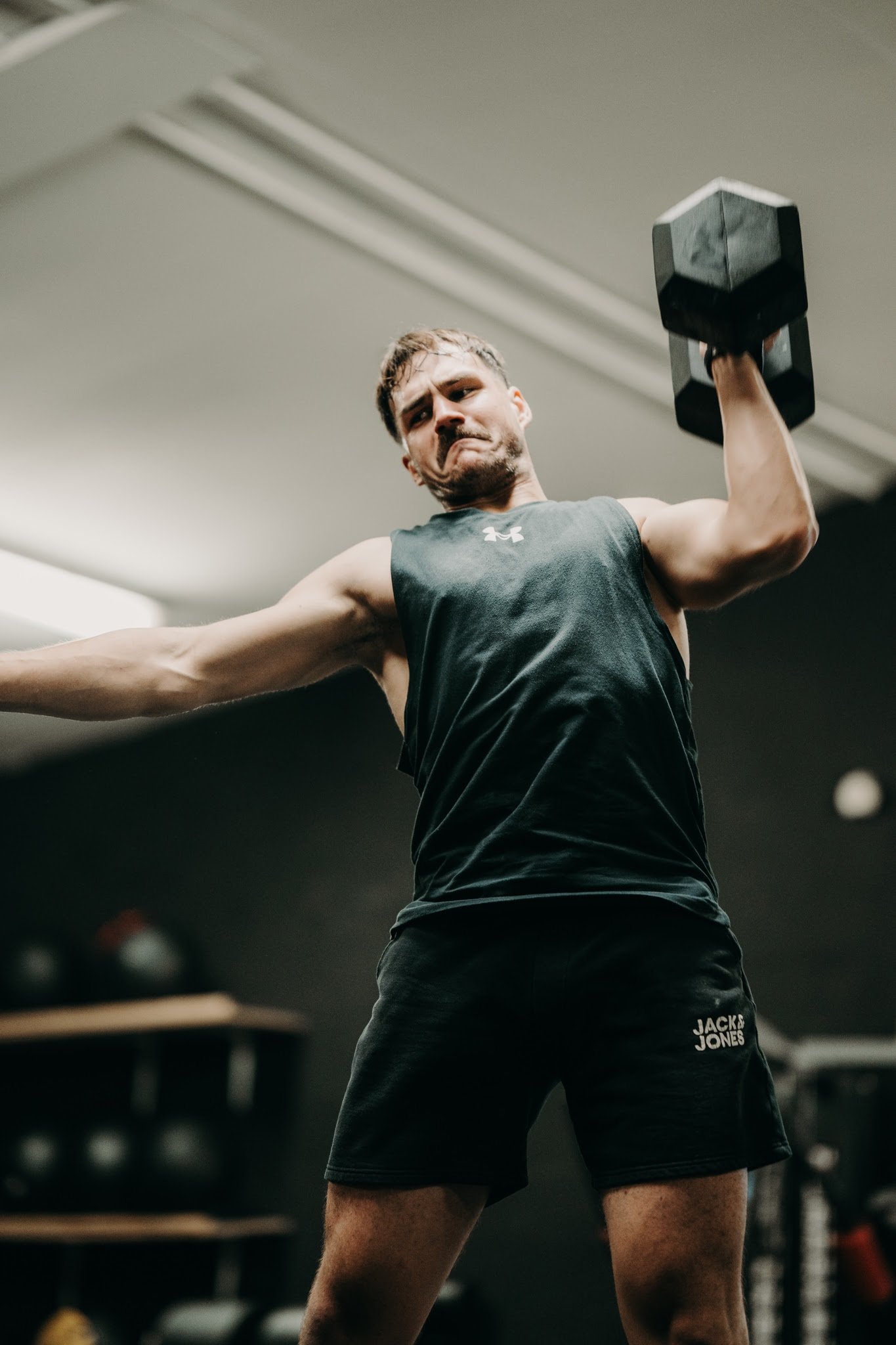 Athlète en développé d'haltère à une main à O'GYM Neufchâteau