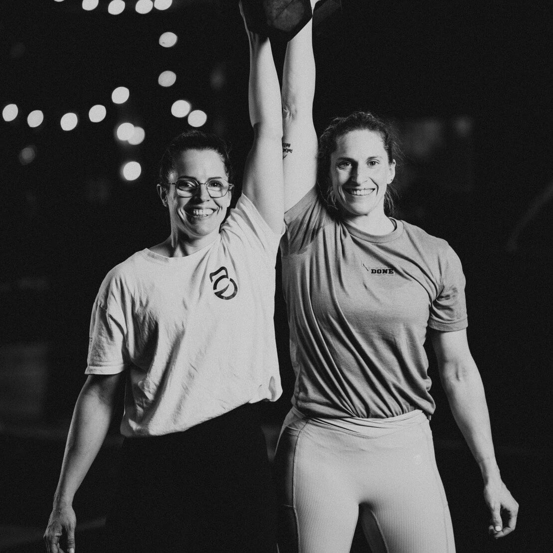 Deux athlètes lèvent un kettlebell au-dessus de la tête à O'GYM Neufchâteau