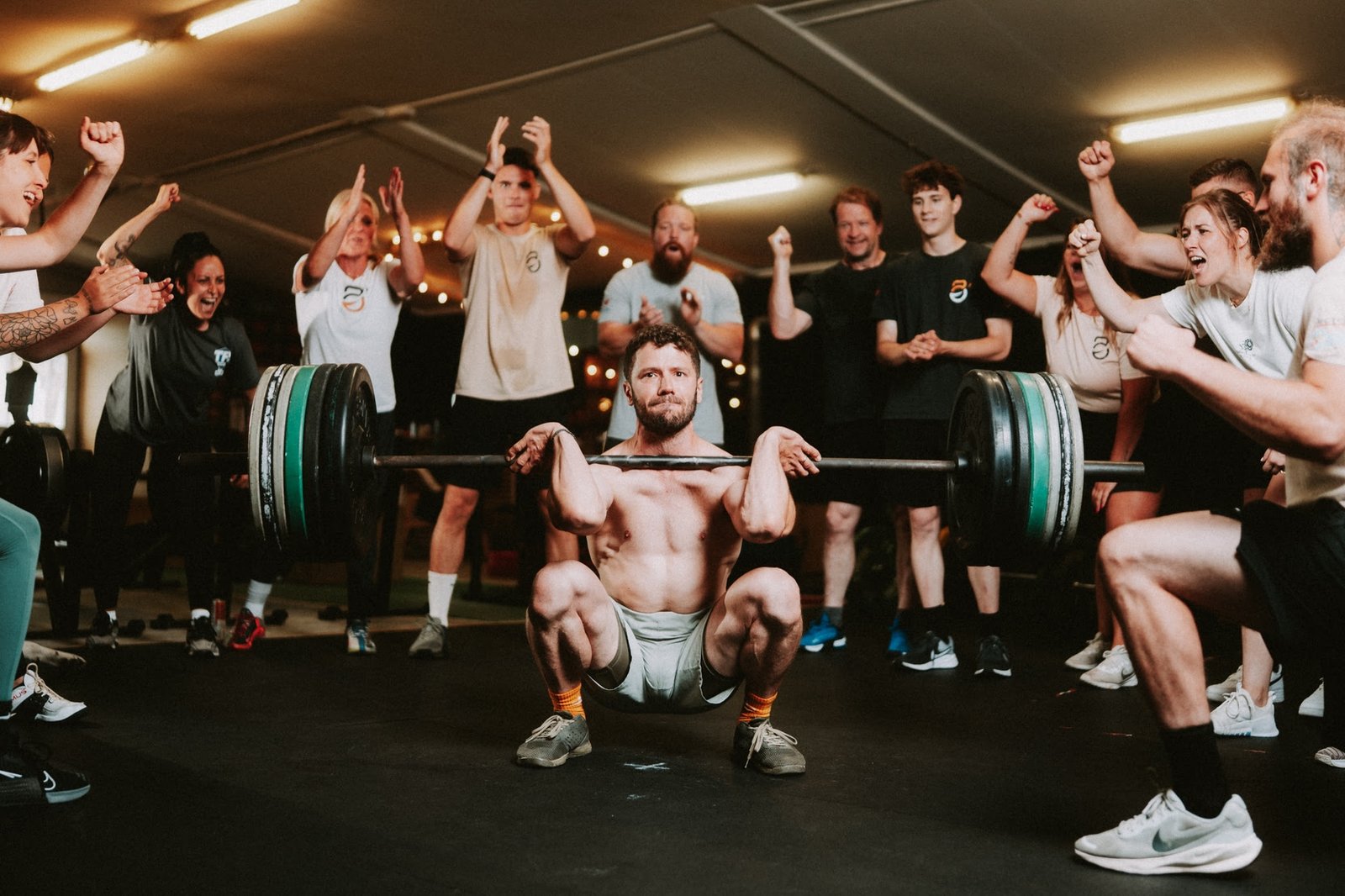 Athlète en épaulé-jeté encouragé par tout le groupe à la salle O'GYM de Neufchâteau